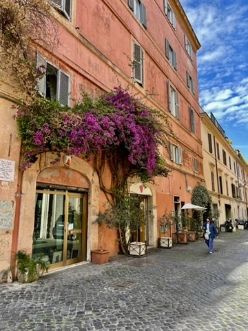 Flower-covered street in Trastevere Rome with cozy cafés