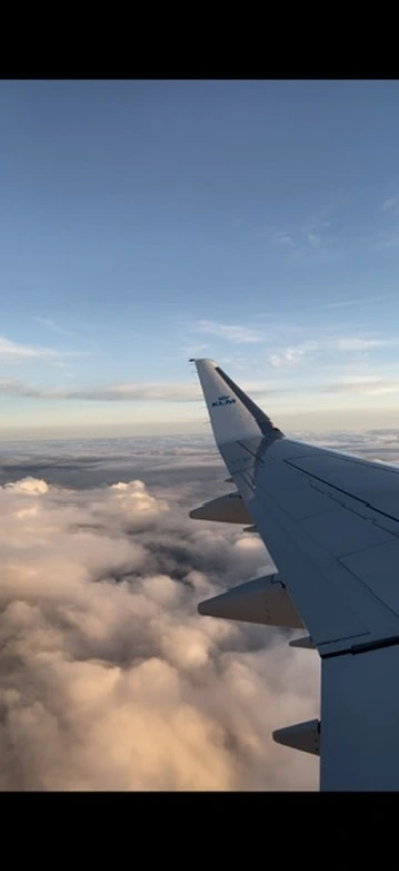 View from airplane window above the clouds – first flight experience with a baby